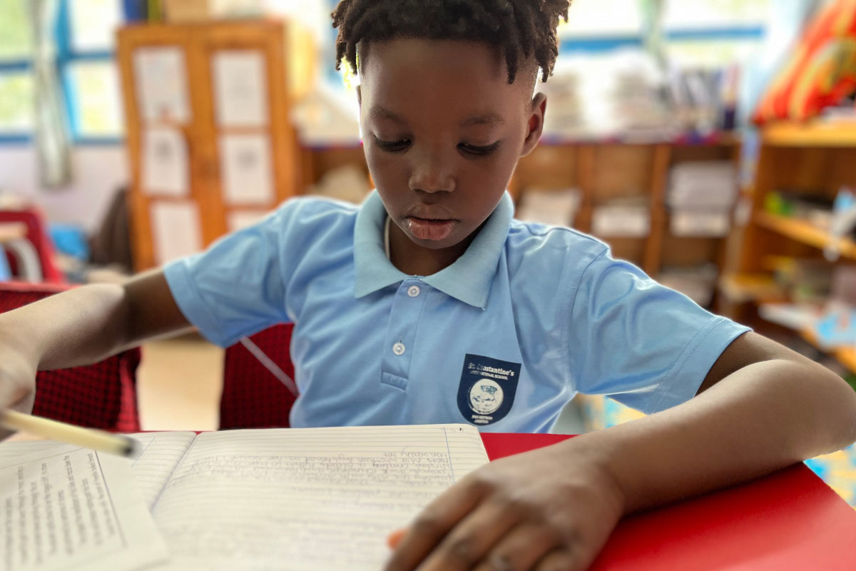 Primary pupil concentrating on handwriting and literacy work in classroom