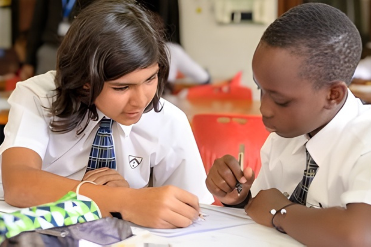 Two pupils working together at a classroom desk during a lesson
