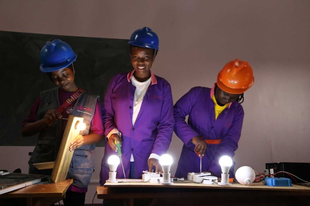 Female and male students receiving practical technical skills training at a Ugandan vocational institute.