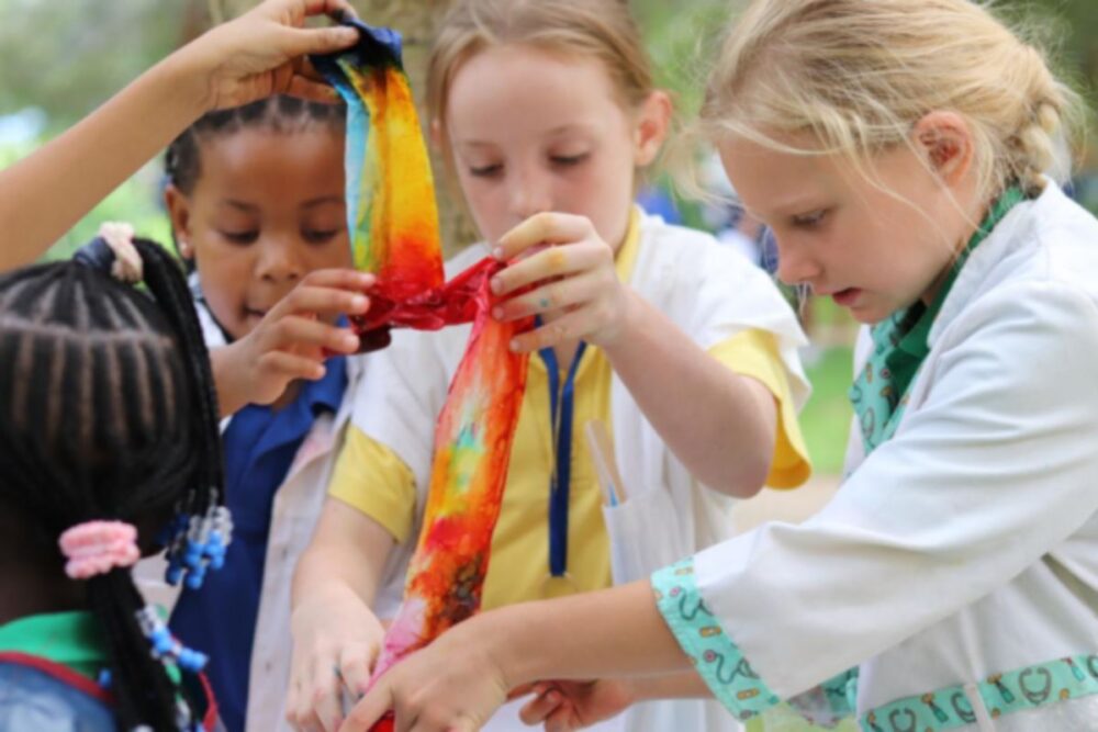 students at baobab college working on a colourful hands on learning activity outdoors