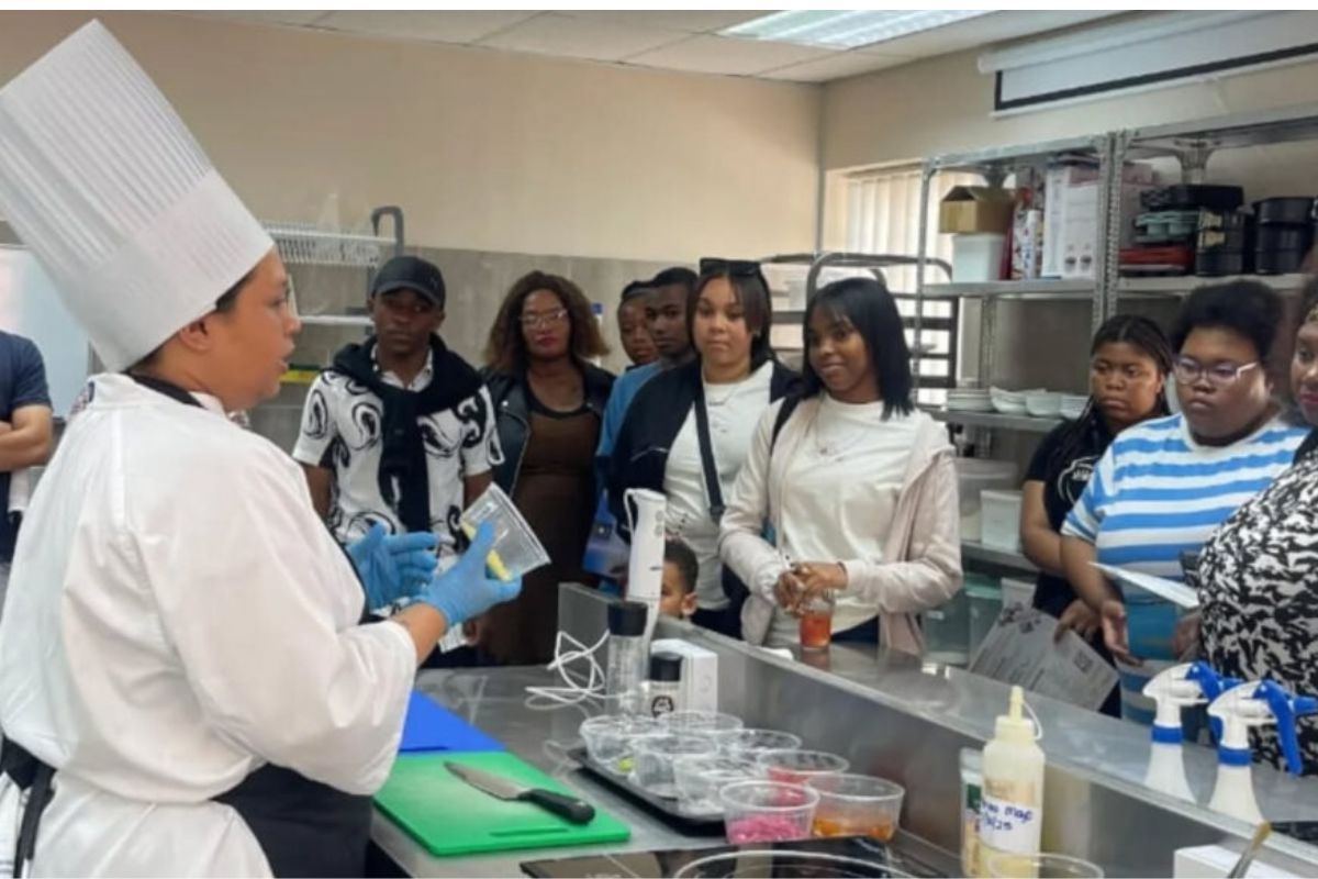 International Hotel School students learning professional culinary skills during a practical hospitality training session