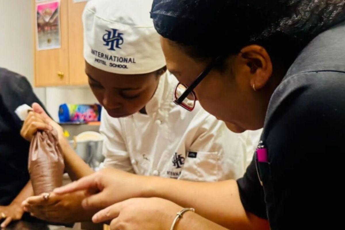 Hospitality students receiving practical chef training in a professional kitchen environment