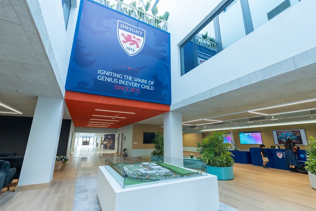 The reception area inside Dwight School Cairo, featuring the school's branding and campus model. Image via Ddwight.edu